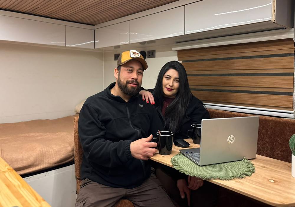 Erik Urrea y Natalia Farías dentro de una camper, con laptop
